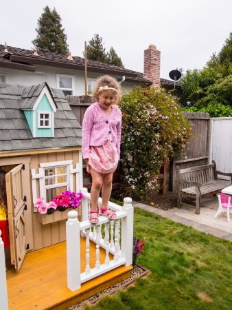 Having fun jumping down from playhouse fense in a garden.の写真素材