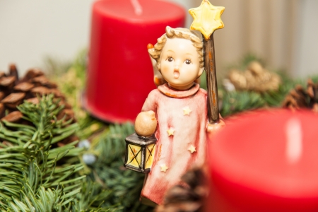 Christmas decorations with angel and red candles on tree branch.の写真素材