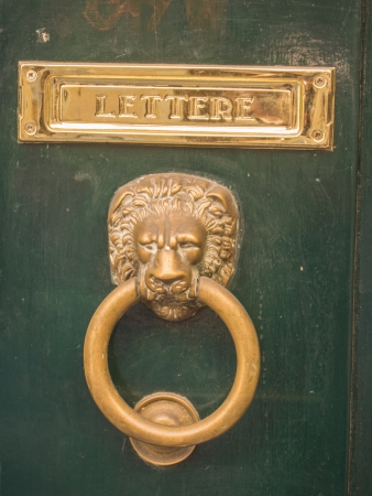 Vintage metal door knocker on a door in Rome, Italy