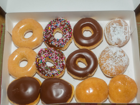 Assorted doughnuts in a white paper box.の写真素材