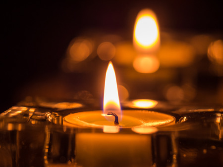 Candle flame glowing in the darkの写真素材