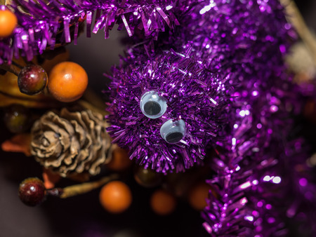 Purple sparkly spider decoration hanging on a door during Halloweenの写真素材