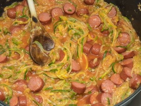 Making of spiral squash spaghetti noodles with sausage and tomato sauce.の写真素材