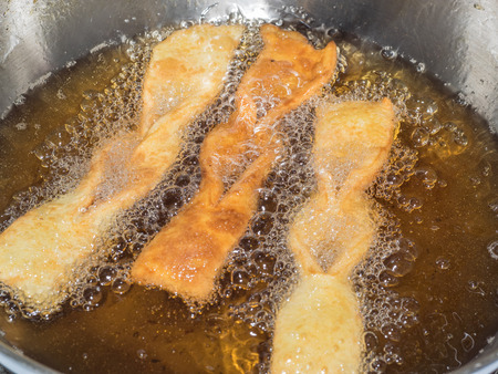Angel wings are a traditional sweet crisp pastry made out of dough that has been shaped into thin twisted ribbons, deep-fried and sprinkled with powdered sugar.の写真素材
