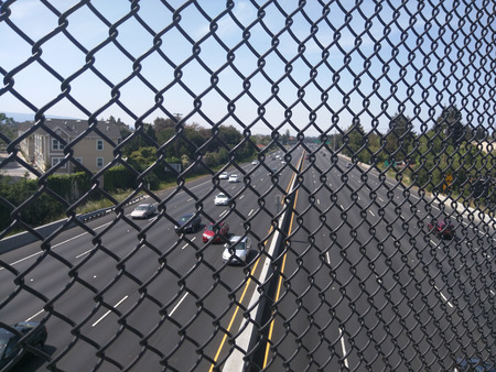 View of Highway 101 through fence from overpass.の写真素材