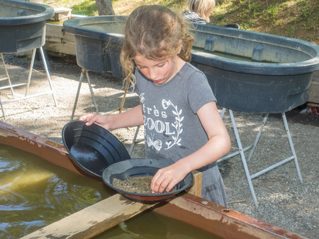 Gold panning is a form of placer mining and traditional mining that extracts gold from a placer deposit using a pan.の写真素材
