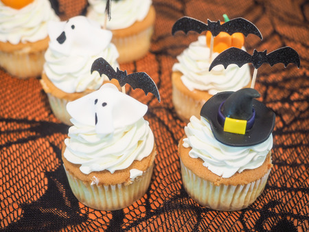 Spooky Halloween cupcakes with white cream and decorations on top.の写真素材