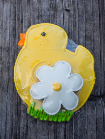 Yellow gingerbread chick cookie with white flower made for Easter celebration