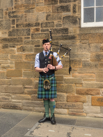 Bagpiper busking with the Great Highland bagpipe on the street in Edinburgh, Scotlandのeditorial素材
