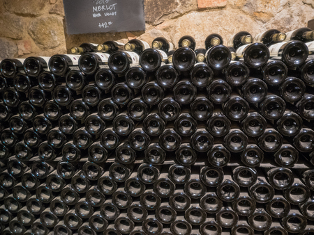 Stacked wine bottles on the rack inside winery cellar.の写真素材