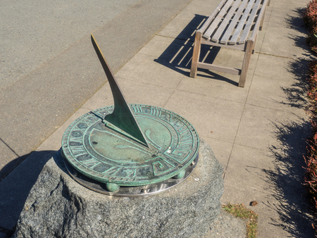 Sundial is a device that tells the time of day by the apparent position of the Sun in the sky. In common designs such as the horizontal sundial, the sun casts a shadow from its style onto a surface marked with lines indicating the hours of the day.の写真素材
