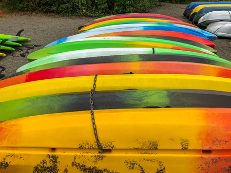 Colorful kayaks stacked on the beach sand.の写真素材