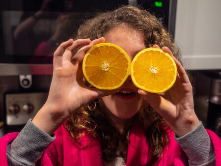 Girl with two half cut oranges.の写真素材