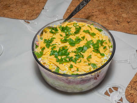 Dressed herring, colloquially known as herring under a fur coat, is a Russian layered salad composed of diced pickled herring covered with layers of grated boiled vegetables (potatoes, carrots, beetroots), chopped onions, and mayonnaise.の写真素材