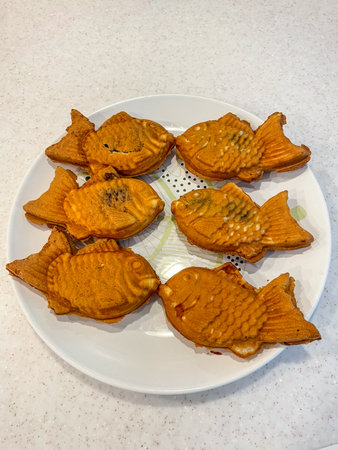Taiyaki is a Japanese fish-shaped cake, commonly sold as street food. It imitates the shape of tai, which it is named after. The most common filling is red bean paste that is made from sweetened adzuki beans.の写真素材