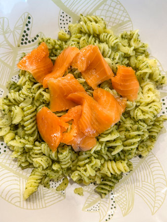 Salmon pesto pasta is an easy, healthy dish loaded with good fats. Use jarred pesto or fresh basil to make your own for the creamy sauce.の写真素材