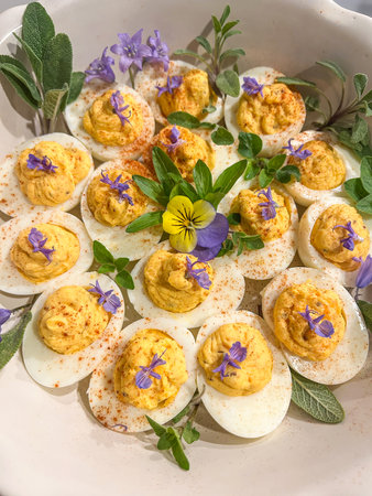 Deviled eggs are hard-boiled eggs that have been peeled, cut in half, with the yolk scooped out and then refilled having been mixed with other ingredients such as mayonnaise, mustard and sprinkled with paprika, cinnamon or curry powder.の写真素材