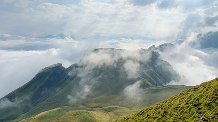Breathtaking view during a hike along the Stoos ridge in Switzerland, where clouds dance around the...