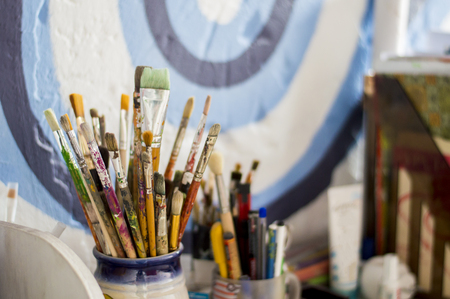 diferent brushes in multicolored paint closeup aの写真素材