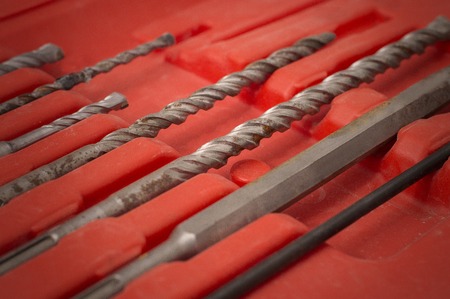 new drill bit set lying on clean concrete background