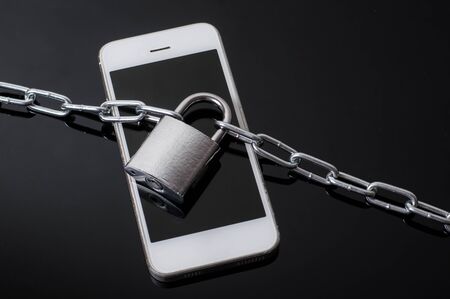 white mobile phone with chain and lockの写真素材