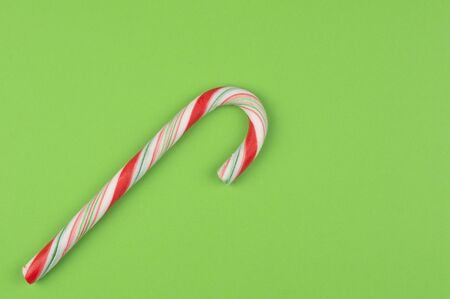 Beautiful colored red-green Christmas candy on a green background flat lay. Place for textの写真素材