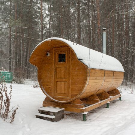 Bath barrel on a background of a winter forest. The first snow is falling. Health careの写真素材