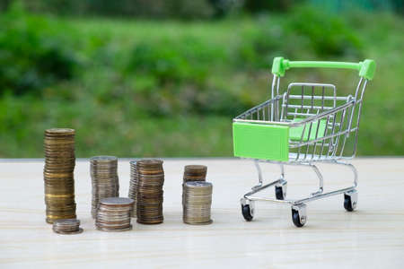 Trolley for groceries and goods from the supermarket and a lot of coins. Business concept, trade,...