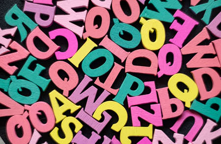 Colored letters of the English alphabet on a black table. Learning to readの写真素材