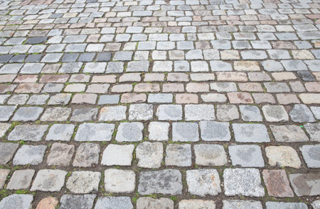 Granite cobblestone pavement. Ancient road surface. Stone sidewalk