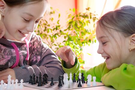 Happy children play chess while being at home.の写真素材