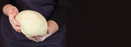 Female hands of the cook hold magnificent dough in hands. Banner for text