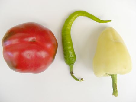 a green hot pepper with a red and a yellow paprikaの写真素材