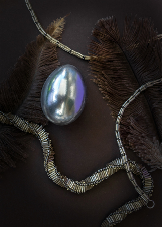 Silver eggs with feather and beaded silver necklaceの写真素材