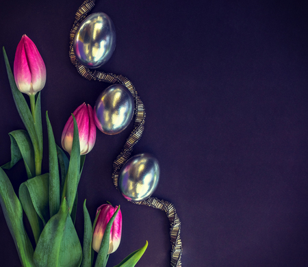 Silver eggs with tulips and beaded silver necklace on a dark background, Easterの写真素材