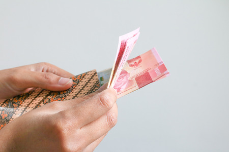 Woman Hand showing Indonesian Money Rupiah on envelopeの写真素材