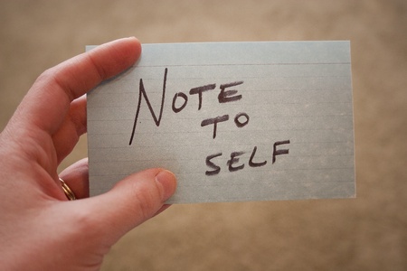 Hand holding notecard with  Note to Self  written on itの写真素材