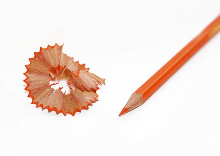 Orange pencil and shavings on white backgroundの写真素材