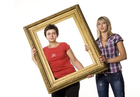 Young women posing with wooden frameの写真素材