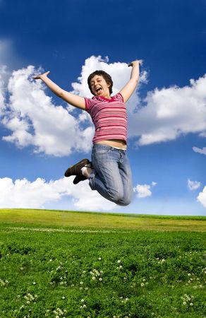  Young happy woman jumping high against blue summer skyの写真素材