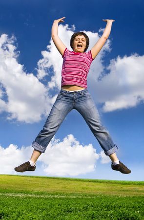  Young happy woman jumping high against blue summer skyの写真素材