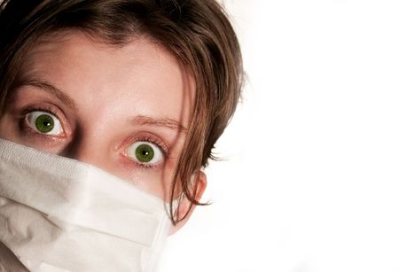 Woman with big green eyes wearing medical mask protecting against flu virusの写真素材