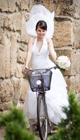 Happy bride riding a bikeの写真素材