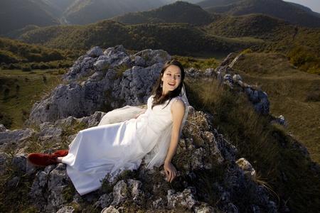 Beautiful bride posing in high mountain scenery の写真素材