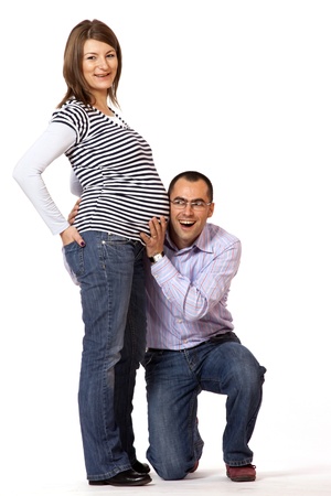Happy young man and his pregnant wife isolated on white の写真素材