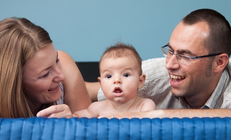 Beautiful young family with baby boy in bedroom