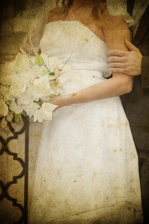 Vintage photo of bride and groom's hands holding wedding bouquet の写真素材