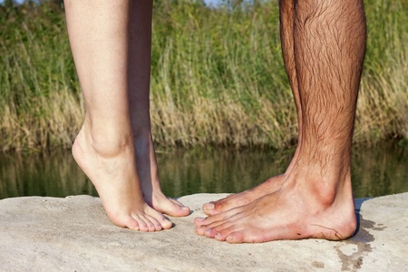 couple feet kissing near lakeの写真素材