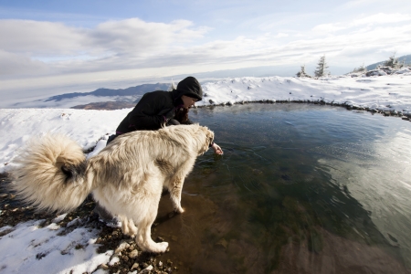 Woman with her dog in snowy mountain scenery