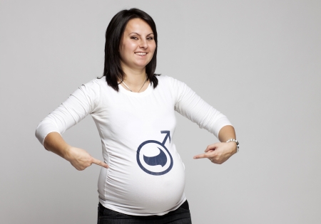 pregnant woman pointing to boy sign on her shirtの写真素材